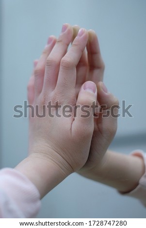 Image of a finger of a girl touching the mirror.