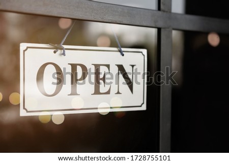A business sign that says open on cafe or restaurant hang on door at entrance. Vintage color tone style.