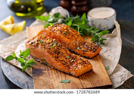 Cedar plank grilled or roasted salmon with herbs, garlic and spices Royalty-Free Stock Photo #1728782689