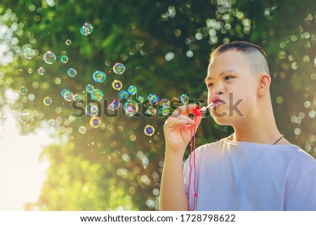 Asian Dawn syndrome boys enjoying outdoors blowing a soap bubbles