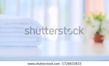 Stack of white clean towels on table in bathroom. Spa. White Cotton Towels Use In Spa Bathroom. Towel Concept. Photo For Hotels and Massage Parlors. Purity and Softness. Towel Textile