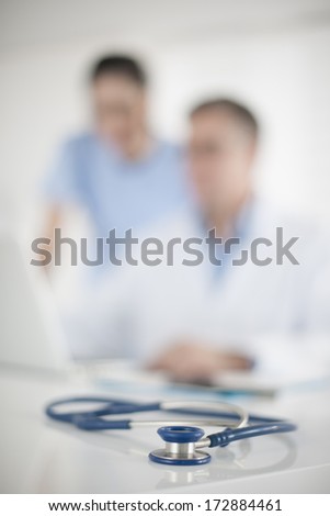 medical team in background and focus on the stÃ?Â?Ã?Â©thoscope at foreground