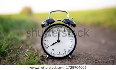 Alarm clock at sunset shows eight o'clock