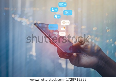 Person using a social media marketing concept on mobile phone with notification icons of like, message, comment and star above smartphone screen. Royalty-Free Stock Photo #1728918238