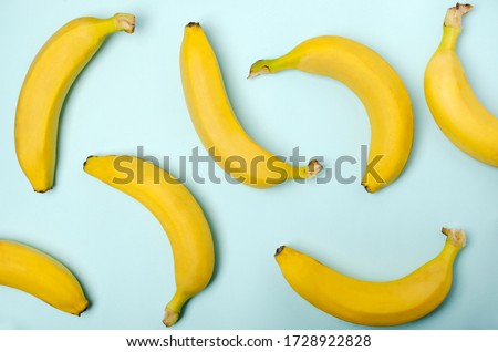 Top view of whole bananas on the blue surface as a decorative background