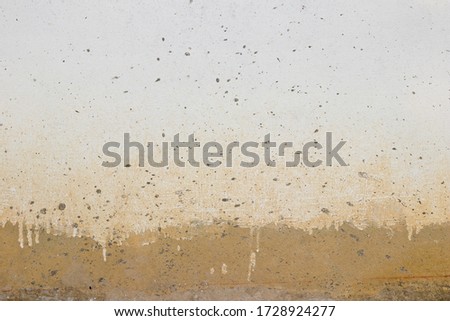 Concrete wall texture with unfinished paint job and mud stain.