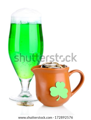 Glass of green beer and pitcher with coins isolated on white