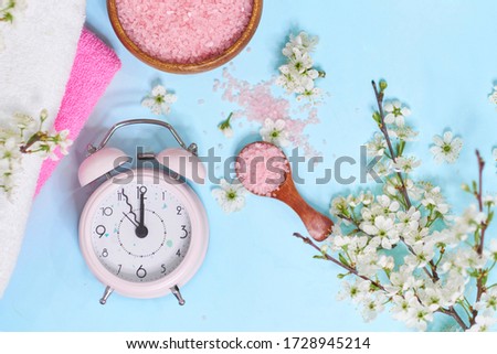 Spa setting spring flowers with towel ,salt in bowl, Spring Time Change, Spring flowers and Alarm Clock.