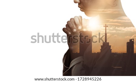 Double exposure of a hand girl praying for city, Hands folded in prayer concept for faith, spirituality and religion, Church in the city with sky background.