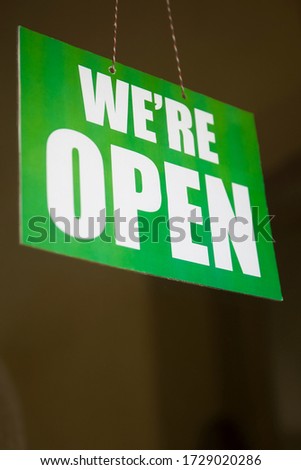Open sign on the glass of the door at the store
