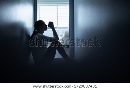 Young woman at home feeling desperate saying a prayer.  Royalty-Free Stock Photo #1729037431