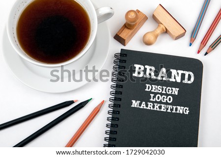 Brand. Design, Logo and Marketing Concept. Black notebook and office supplies on a white office desk