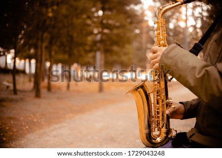 Man playing Golden saxophone in the street. Saxophone and jazz day concept. Top horizontal view copyspace