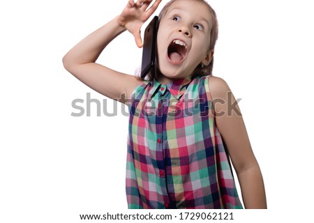 Cute little girl drops a mobile phone. Studio photo on a white background.