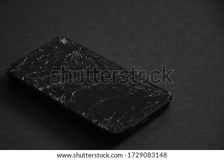 broken old smartphone on black background