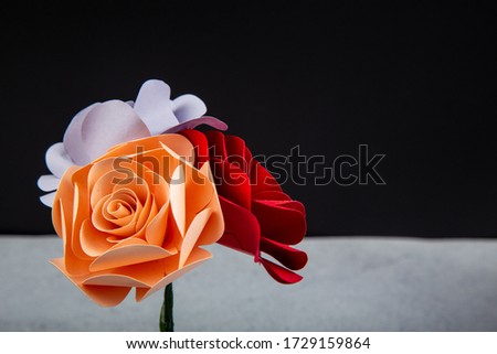 A colorful roses make by paper on black background.