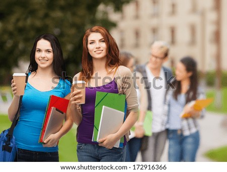 education, technology and people concept - two smiling students with bag, folders, tablet pc and takeaway coffee standing