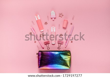 Back to school concept notepad, pencil case, stationery and school supplies. Top horizontal view copyspace pink abstract background