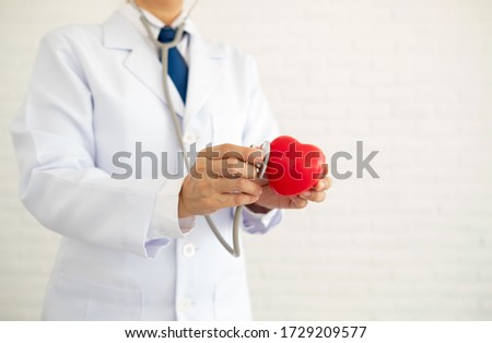 Doctor holding stethoscope examining heart. heart health care concept.