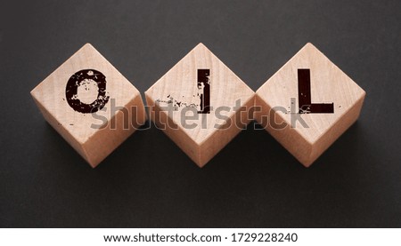 Oil text word on wooden cubes with letters on black. Oil prices dynamics world economy business concept.