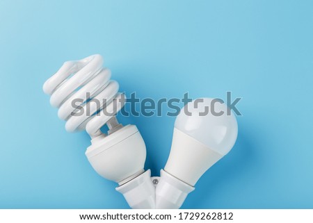 LED light bulb and energy saving in a double base on a blue background.