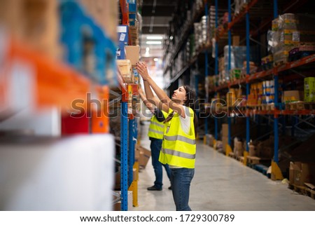 Workers in warehouse review the goods	
