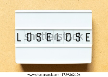 Lightbox with word lose lose on wood background