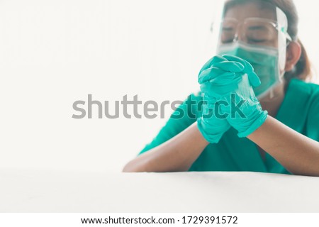 Doctor at hospital wearing medical mask to protect against coronavirus COVID-19.Doctor praying in hospital room with hope.Healthcare medical and religion.Church online in sunday service.Online church.