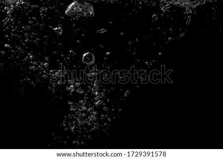 A bubble splash in transparent clear water liquid on a black nature background
