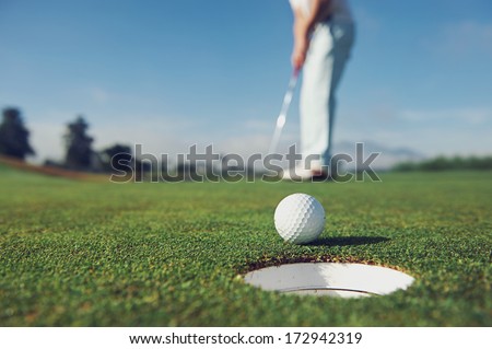 Golf man putting on green for birdie while on vacation Royalty-Free Stock Photo #172942319