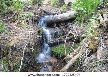The picture shows a small stream with a waterfall.