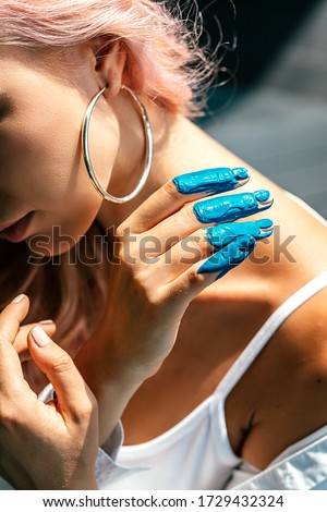 Feel the moment. Close up of woman hand dirty with blue acrylic paint. Female artist using hands for making art. Creative finger painting. Vertical shot. Selective focus