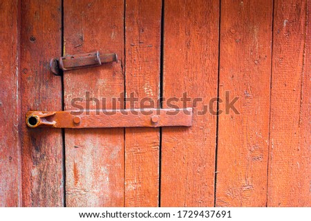 Wooden old door with a lock and leftover paint. Texture with an unusual pattern. Computer desktop wallpaper.
