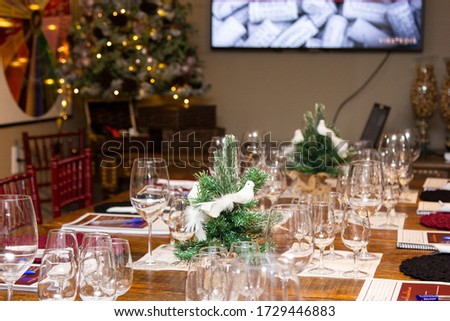 Wooden table decorated with Christmas theme and wine glasses.