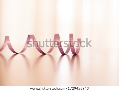 Birthday ribbon curling across a table with a bright background