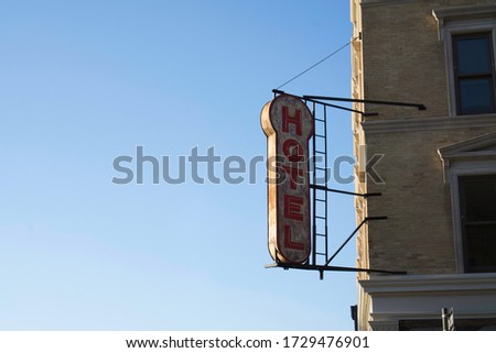 Old style looking hotel sign attached to a building. Reg letters