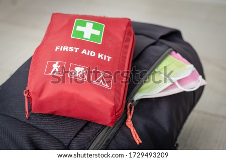 Backpack with   two face protection mask  and   first aid  kit  ready for couple  mountain trip .Measures to avoid crowded and contamination with covid -19 after leaving the quarantine period . Royalty-Free Stock Photo #1729493209