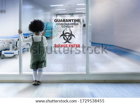 Dark skinned boy stood and looking out of the window glass which blocked the disease quarantine area, Coronavirus and covid19 concept