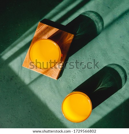 Summer creative photography with sunlight and shadows of orange juice.