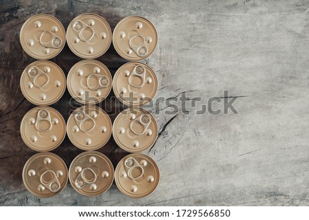 Metal closed canned food on a wooden background. Top view. Copy, empty space for text
