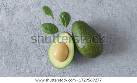 Fresh avocado and slice with leaves on gray stone background. Copy space for your text. Top view and flat lay