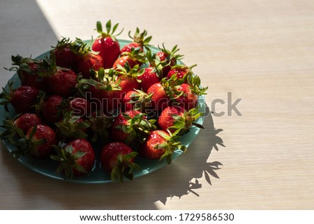the dark side of the strawberry is half lit and the other half in the shade