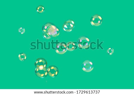 Soap bubbles isolated on a green background. Copy space. 