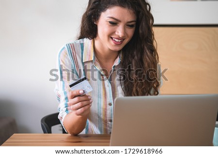 Happy woman holding a credit card and shopping from the internet stock photo