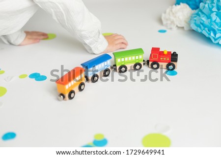 a little boy plays with a train. the child's birthday. decorations balloons and flags