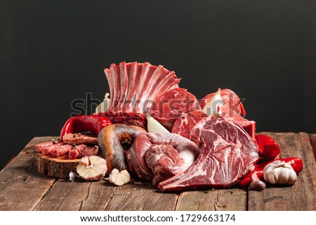 A lot of raw fresh juicy fermented meat. Beef uncooked steaks on a wooden table. Horizontal view