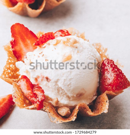 Vanilla Ice Cream Scoops with strawberry pieces into the waffle basket, easy dessert at home