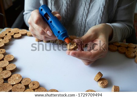 Homemade cork panel, woman makes wine cork note board, selective focus
