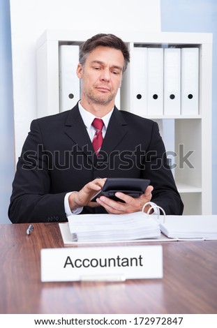 Portrait Of Mature Male Accountant Working At Office