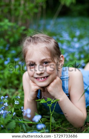Portrait of eight-year-old  girl with forget-me-nots flowers